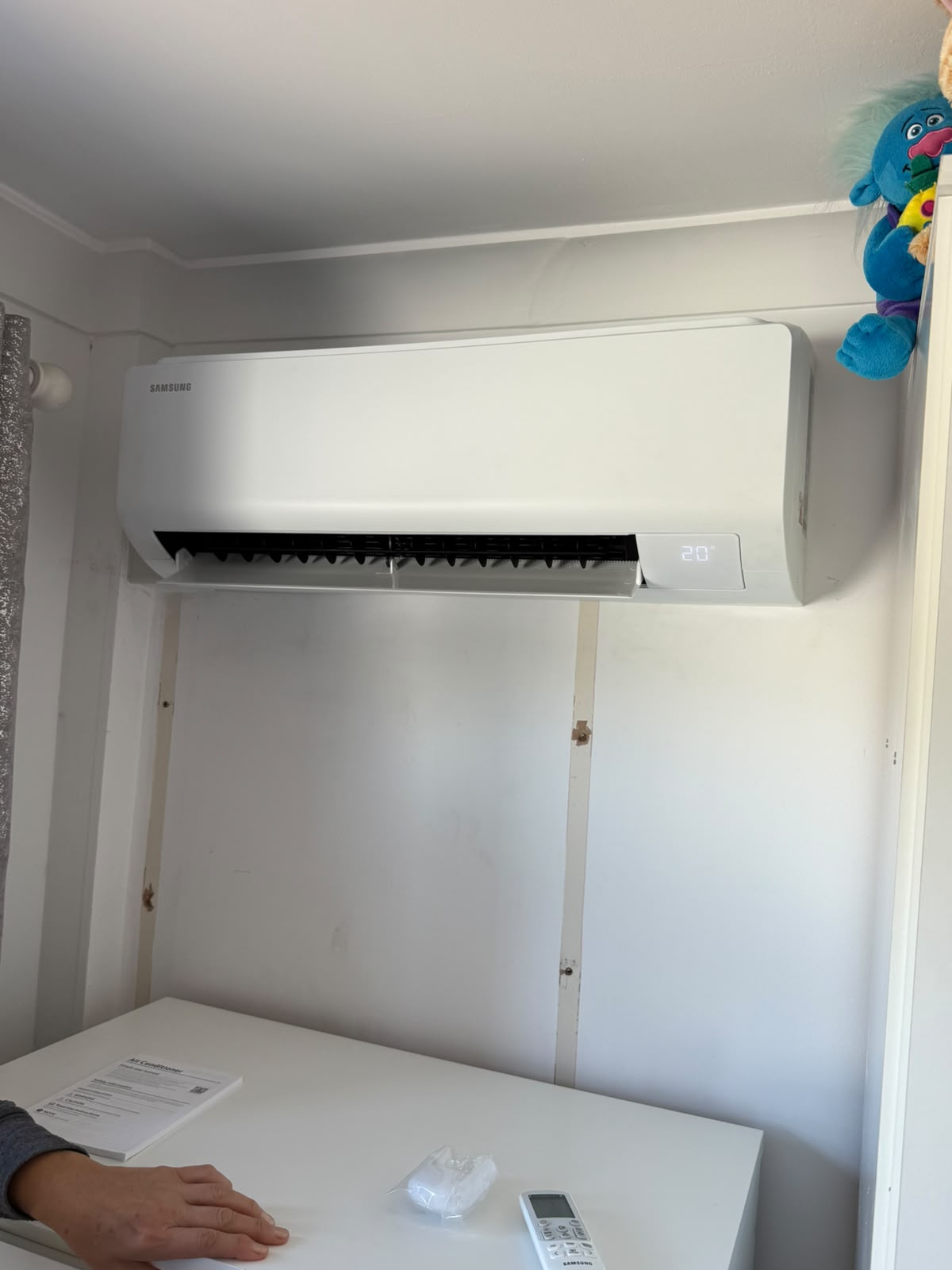 Wall-mounted indoor split air conditioning unit in residential bedroom